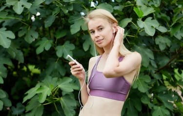 運動中にオーディオブックを聞いている女性の画像